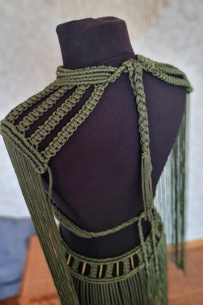Green macrame top on a mannequin with a blurred background