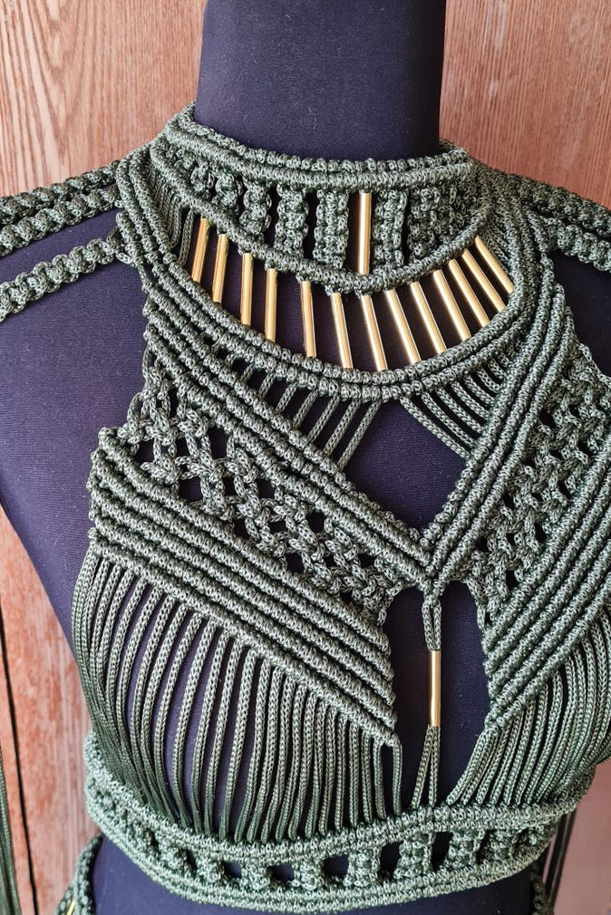 Green macrame top on a mannequin against a wooden background