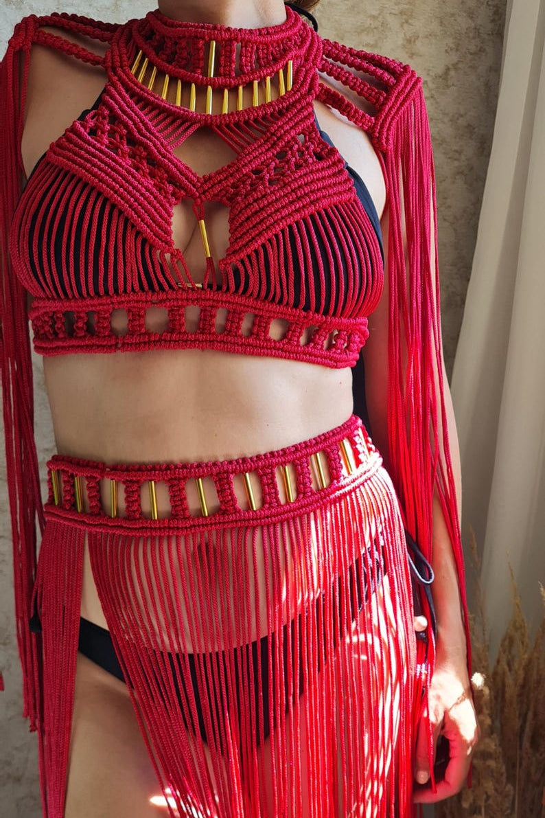 Red macramé top and skirt with gold accents on a neutral background